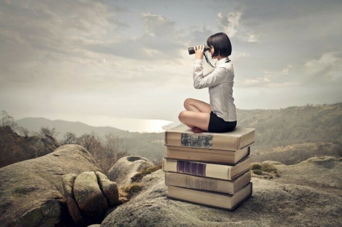 Fotolia 53693049 Subscription XXL 700x465 Девушка с биноклем на книгах Girl with binoculars on the books